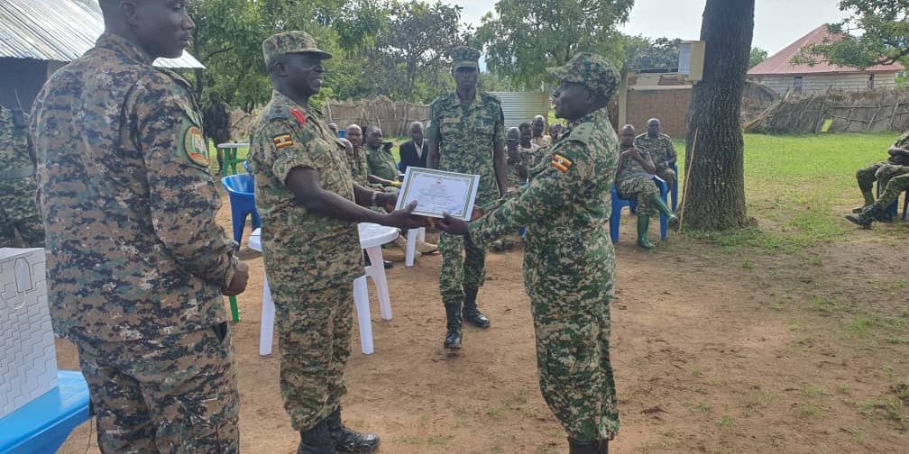 Third Division Deputy Commander Col. David Opeero awarding one of the trainees a certificate.