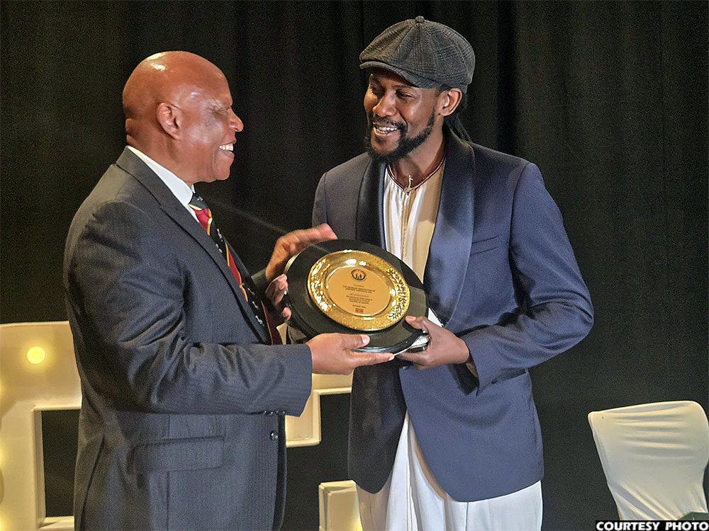 Maj. Gen. Apollo Kasiita-Gowa (left) hands over a gift to Geoffrey Gumikiriza, the host association president