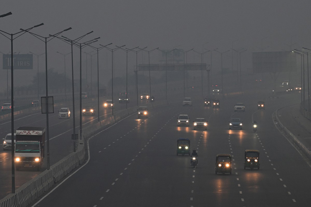Commuters drive amid heavy smog in New Delhi on October 21, 2025, as haze engulfed the city skyline a day after Diwali celebrations, the Hindu festival of lights. (Photo by Arun SANKAR / AFP)