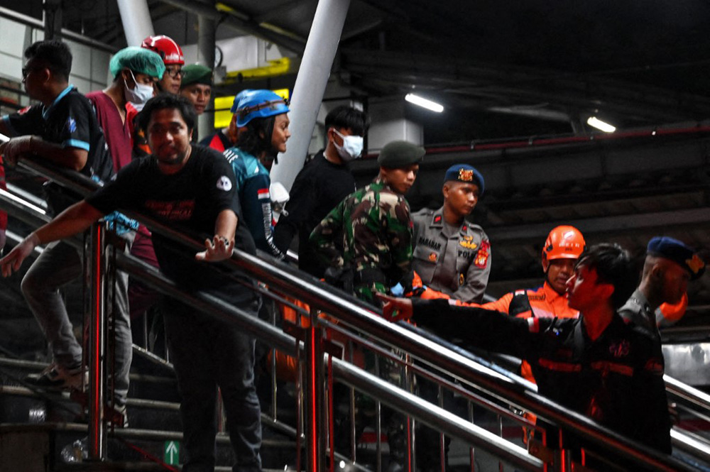 Joint SAR officers evacuate accident victims from the KRL Commuterline and KA Argo Bromo Anggrek trains on the Gambir-Surabaya Pasar Turi route at East Bekasi Station, Bekasi, West Java, Indonesia, on April 27, 2026. (Photo by Edi Ismail/NurPhoto via AFP) 