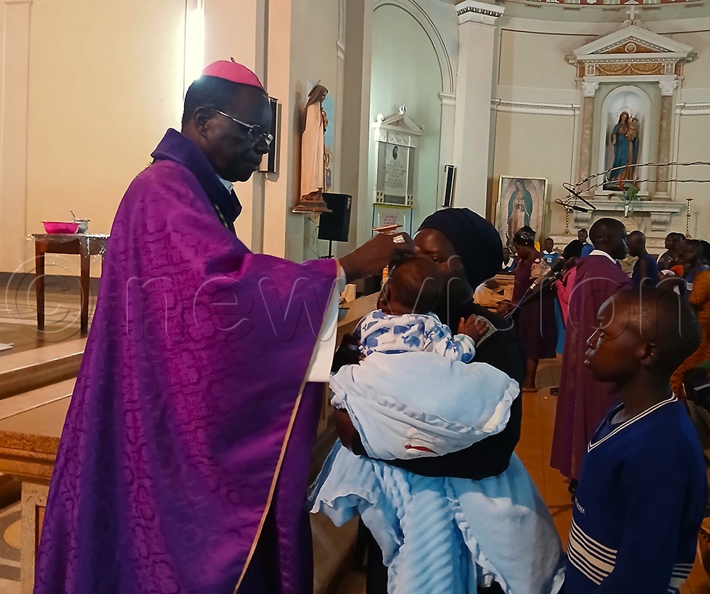   Raphael P&rsquo;Mony Wokorach, Archbishop of Gulu Archdiocese putting ash on th forehead of a christian. (Photo by Claude Omona)