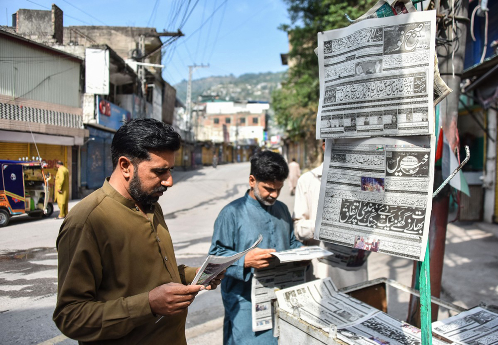 Residents read morning Urdu newspapers with the headline 'The ceasefire between Pakistan and India' on a roadside in Muzaffarabad, the capital of Pakistan-administered Kashmir, on May 11, 2025. India and Pakistan traded accusations of ceasefire violations early on May 11, hours after US President Donald Trump announced that the nuclear-armed neighbours had stepped back from the brink of full-blown war.