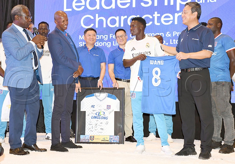 Linglong chairman Wang Feng (2nd right) is presented a jersey by SC Villa captain David Owori as CEO Willam Nkemba (left) and SC Villa president Omar Mandela (3rd right) alongside other team members as Linglong's Kevin and Tim Yin look on at the MAZ complex. Photo by Michael Nsubuga