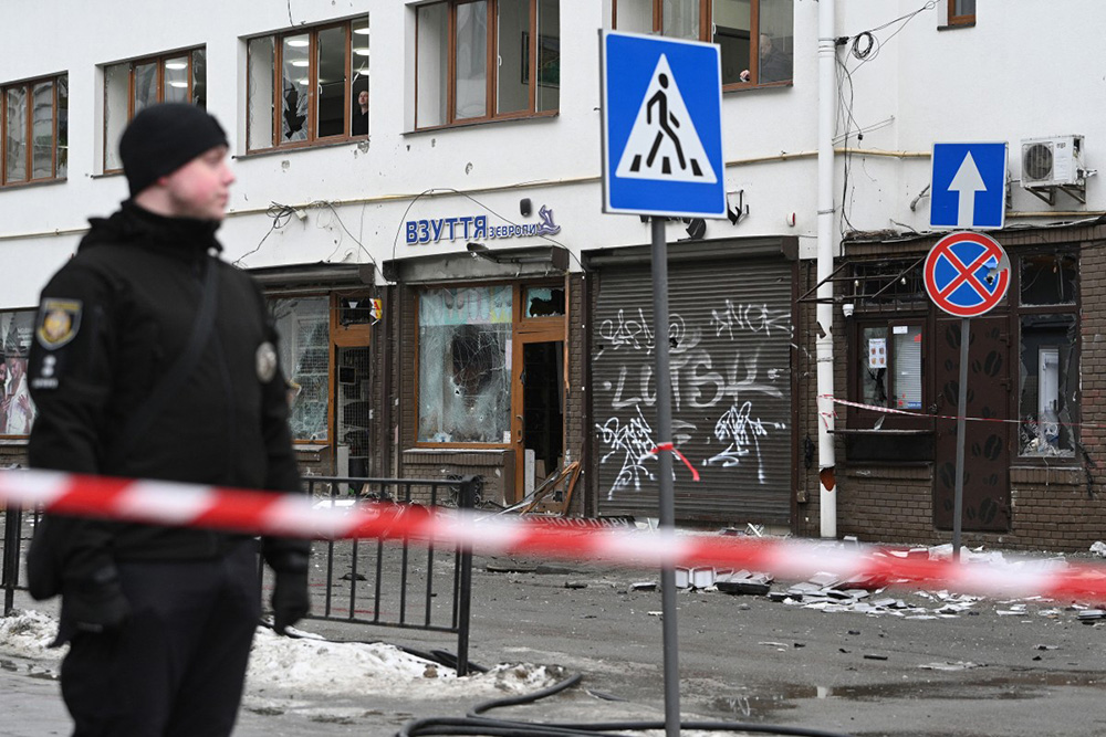 A Ukrainian police officer secures an area at the site of an explosion that rocked a shop in Lviv on February 22, 2026, amid the Russian invasion of Ukraine. (Photo by YURIY DYACHYSHYN / AFP)