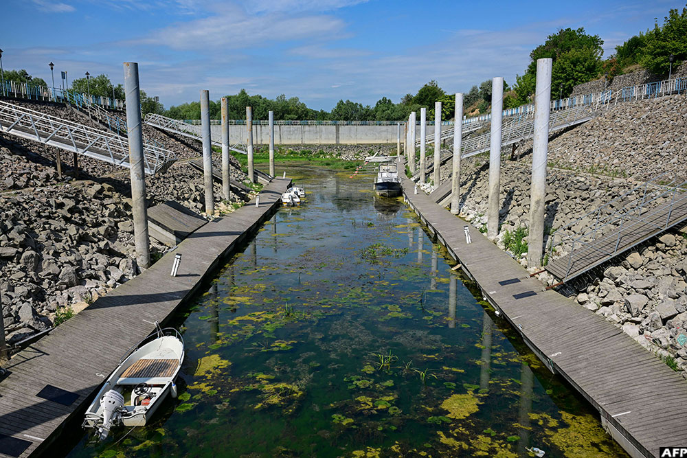 Boats lie in the shallow water of the Danube river in the tourist port of Corabia