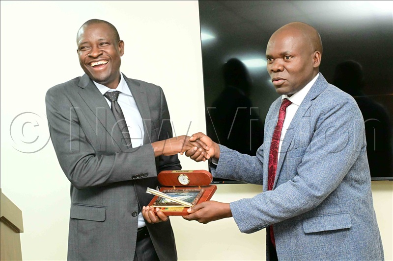Brig General Maxwell Masuku (R), who led a delegation from Zimbabwe, handed over a gift to Dr. Mathias Magoola, the founder Dei Biopharma pharmaceutical factories in Matugga, Wakiso district.