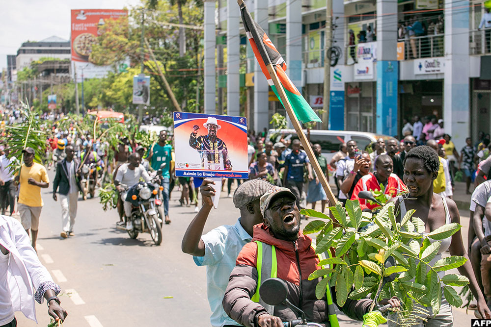 Mourners holding tree branches gather in the streets of Kisumu on October 15, 2025 following the death of Odinga.