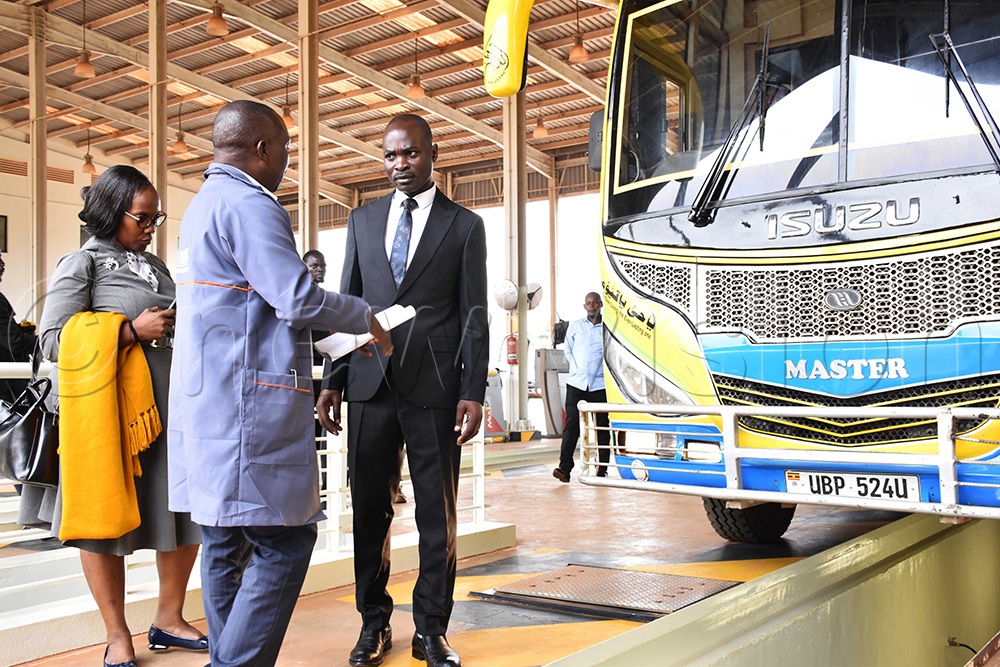 Eng. Kharim Kibuuka, the head of Motor Vehicle Inspection Section from the Ministry of Works and Transport sharing a light moment with Fred Byamukama, the state minister for Works and Transport during his (Byamukama's) visit meeting with bus drivers at the Ministry of Works and Transport vehicle inspection centre in Namanve. (Photo by Simon Peter Tumwine)