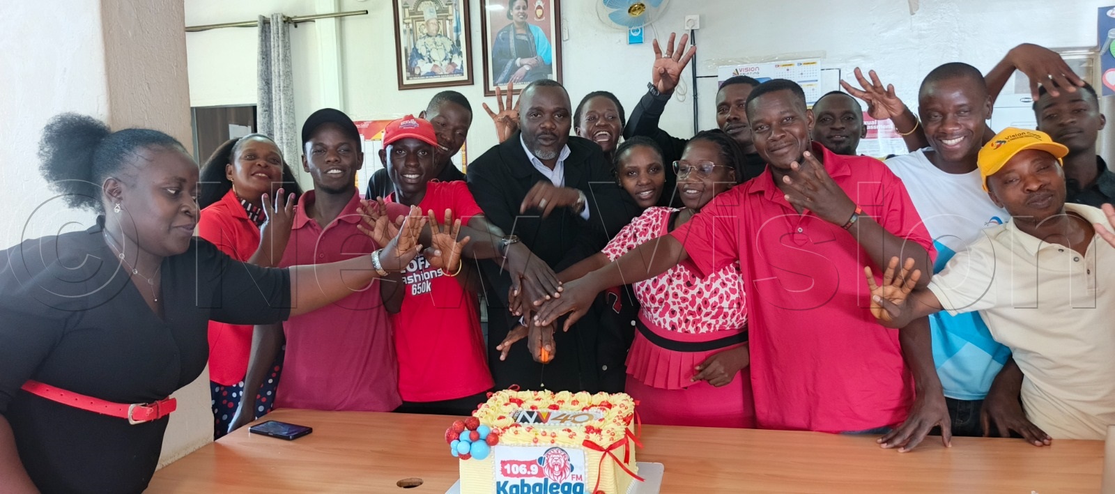 106.9 Kabalega FM team cutting cake.