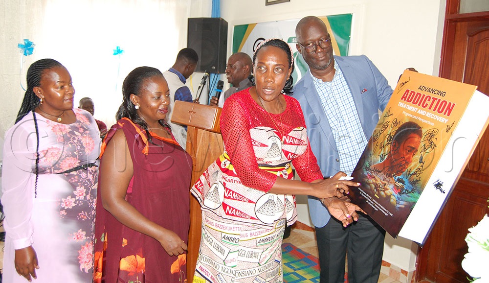 Serenity Centre staff-members signing on the dummy of the silver jubilee monumental book after its launching. (Credit: Mathias  Mazinga)