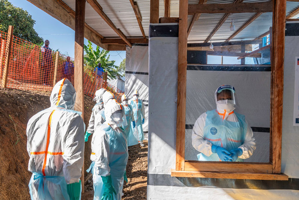 Health workers stand in a new Ebola treatment center during a visit of Tedros Adhanom Ghebreyesus, Director-General of the World Health Organization (WHO), in Bunia, in the northeastern Democratic Republic of the Congo, on May 31, 2026. (Credit: AFP)
