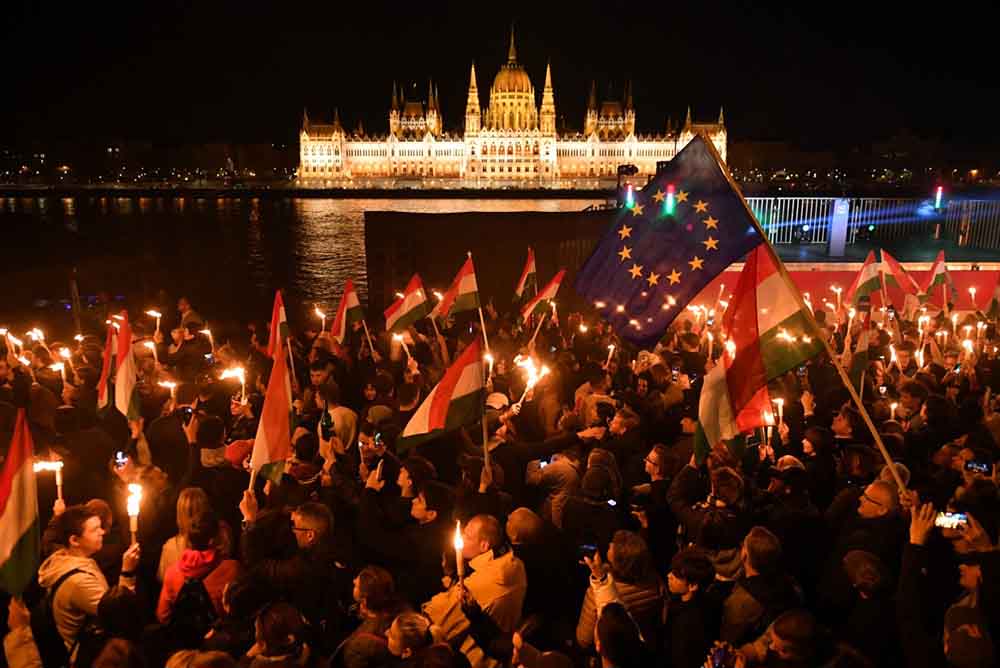 Supporters of the pro-European conservative TISZA party celebrate during the election night on the banks on the river Danube with the Parliament building in the background, in Budapest after the general election in Hungary, on April 12, 2026. (Credit: AFP)