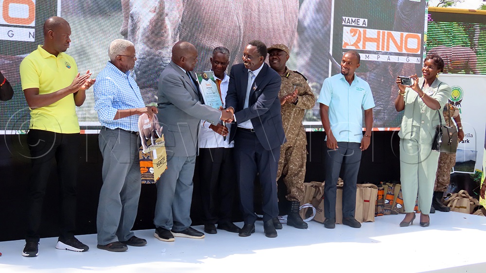 One of the Rhinoes was named Jane Goodall, and the ED Jane Goodall Institute Uganda, James...receives the certificate from Minister of Tourism Wildlife and Antiquities Tom Butime and Minister of State for Tourism Martin Mugarra. (Photo by Titus Kakembo)