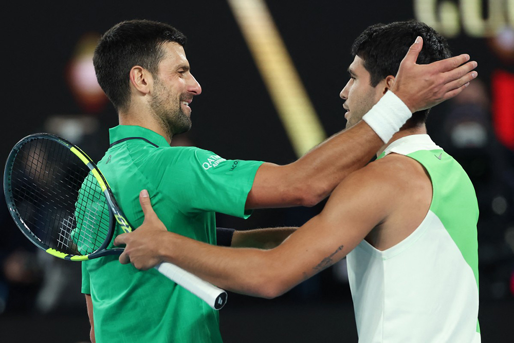 Serbia's Novak Djokovic (L) greets Spain's Carlos Alcaraz on his victory after their men's singles final match on day fifteen of the Australian Open tennis tournament in Melbourne on February 1, 2026.