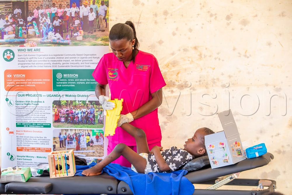 A Physiotherapist from BOK giving therapeutic exercises and massages to a child with walking disability. ( Photo by Jovita Mirembe)