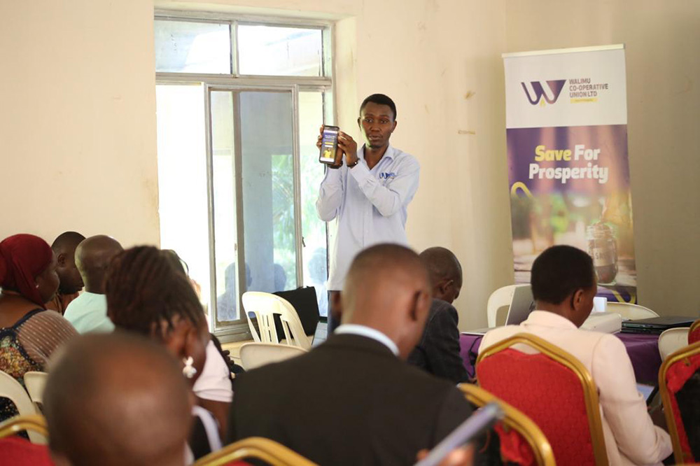 A staff of Walimu Cooperative Union demonstrating to stakeholders how the loan digital system works during the stakeholders’ engagement in Iganga on Tuesday, August 26, 2025. (Credit: Walimu)