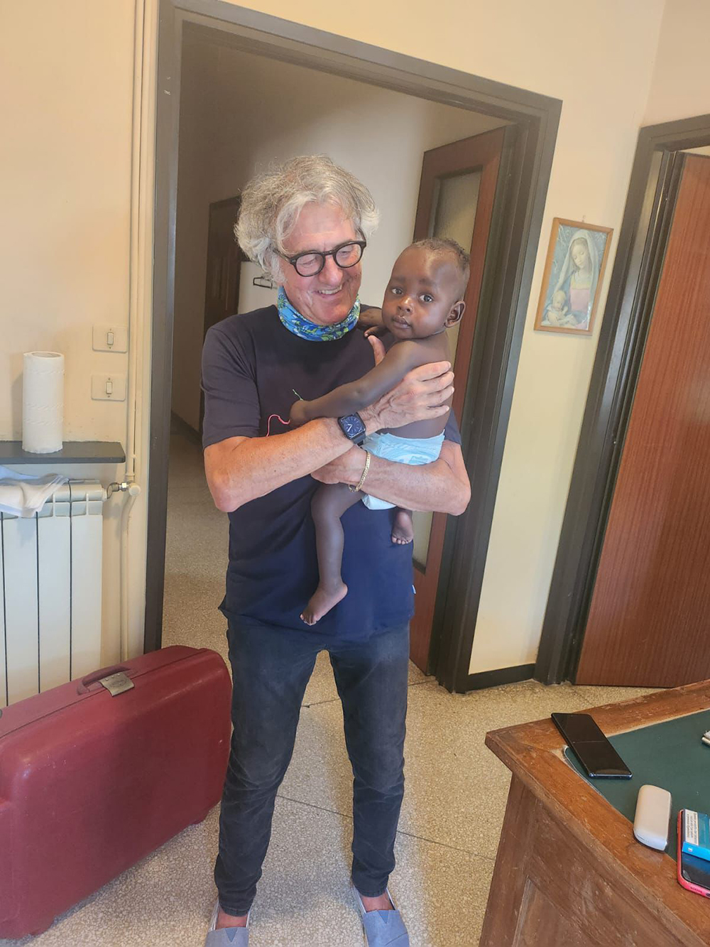 Giacomo carrying Jeremiah Walukale before return to Uganda with his mother after surgery in Italy 