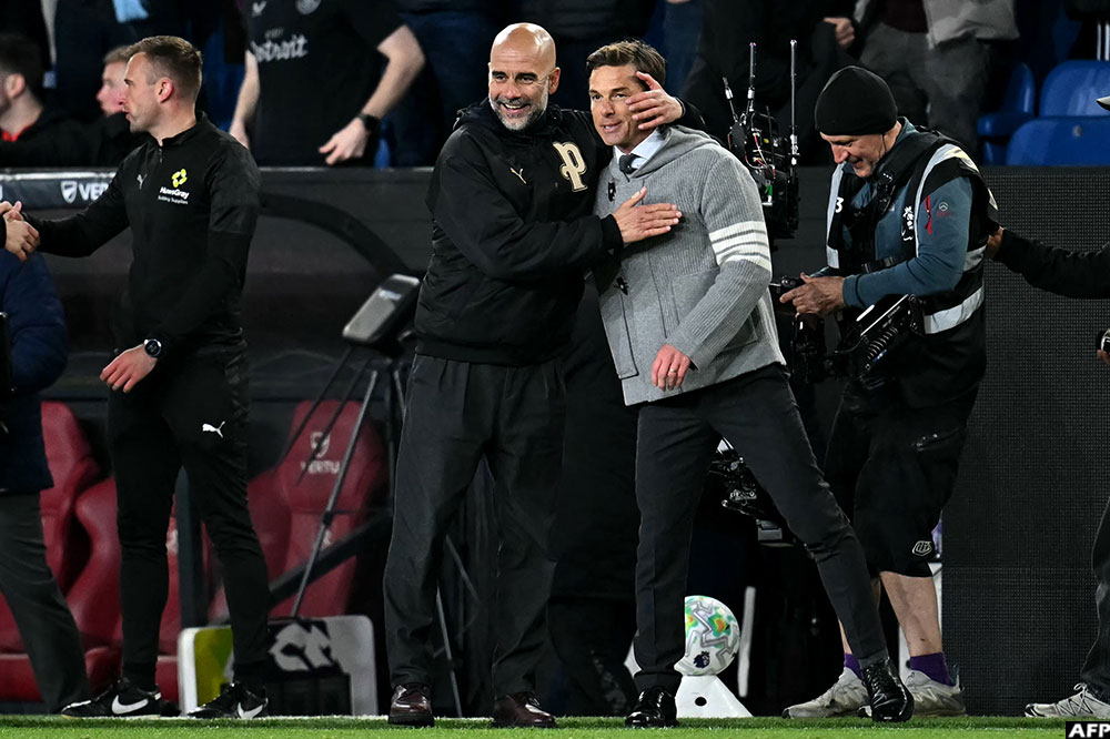 Manchester City's manager Pep Guardiola consoles Burnley's manager Scott Parker after the game