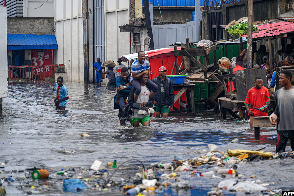 Waste material is seen on a flooded street in the Limete district of Kinshasa on October 19, 2024 after the Kalamu river overflowed its banks following torrential rains 