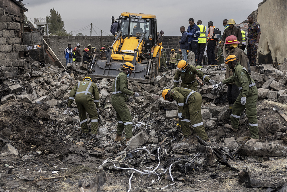 Rescuers work between wreckage parts at a scene where a Kenyan medical plane crashed, killing at least 6 people, on the outskirts of Nairobi on August 7, 2025. 