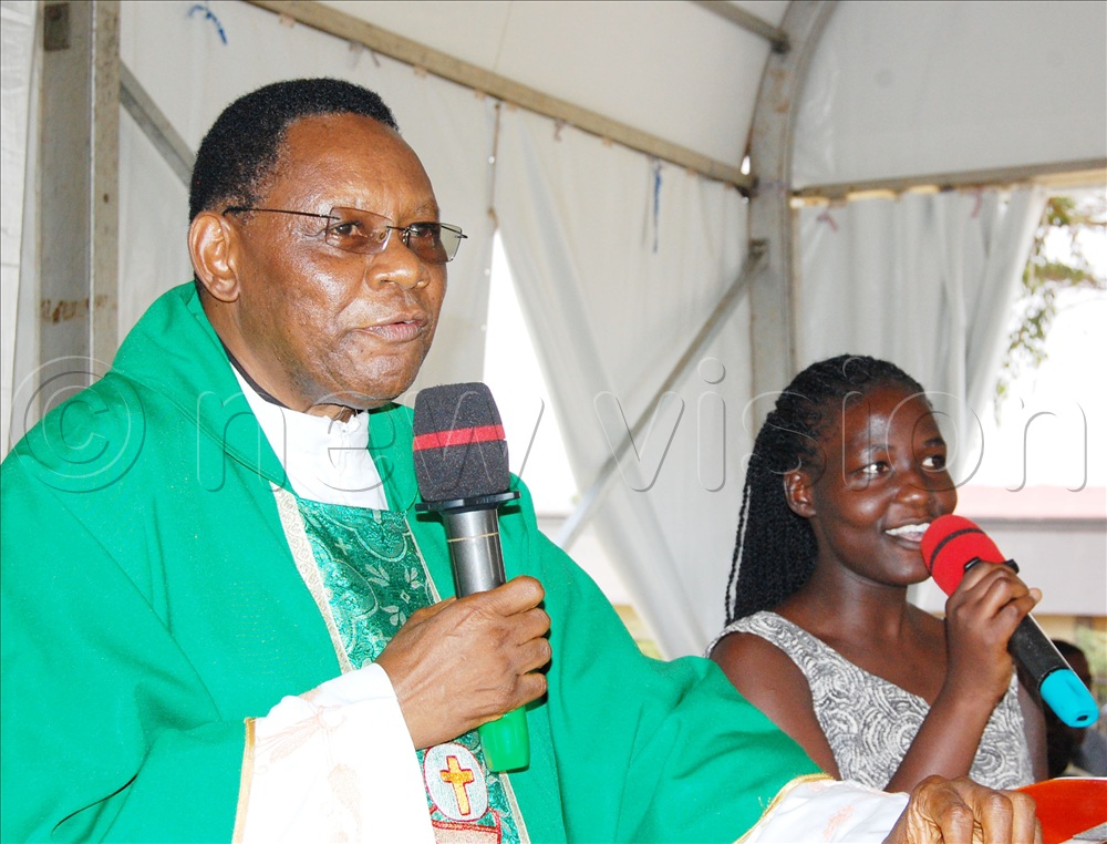 The National Director of the Devotion of St. Jude Thaddeus, Fr. Joseph Mary Bbuye sings a praise and worship chorus with one of the church's youthful musical ministers.