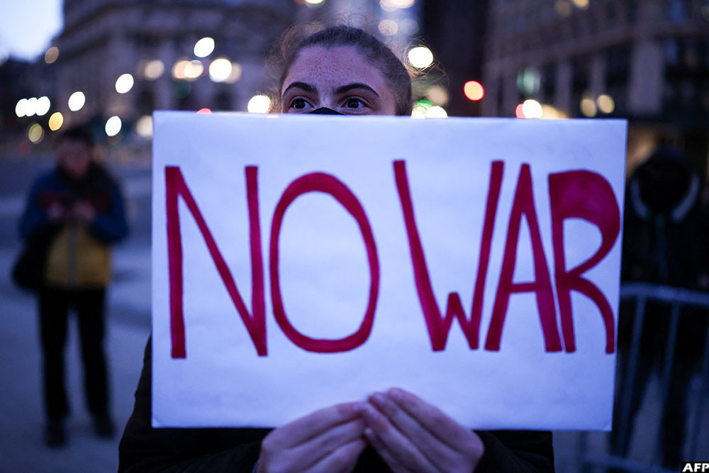 A demonstrator holds a sign during a protest against US military action in Iran in the Manhattan borough of New York City on April 7, 2026