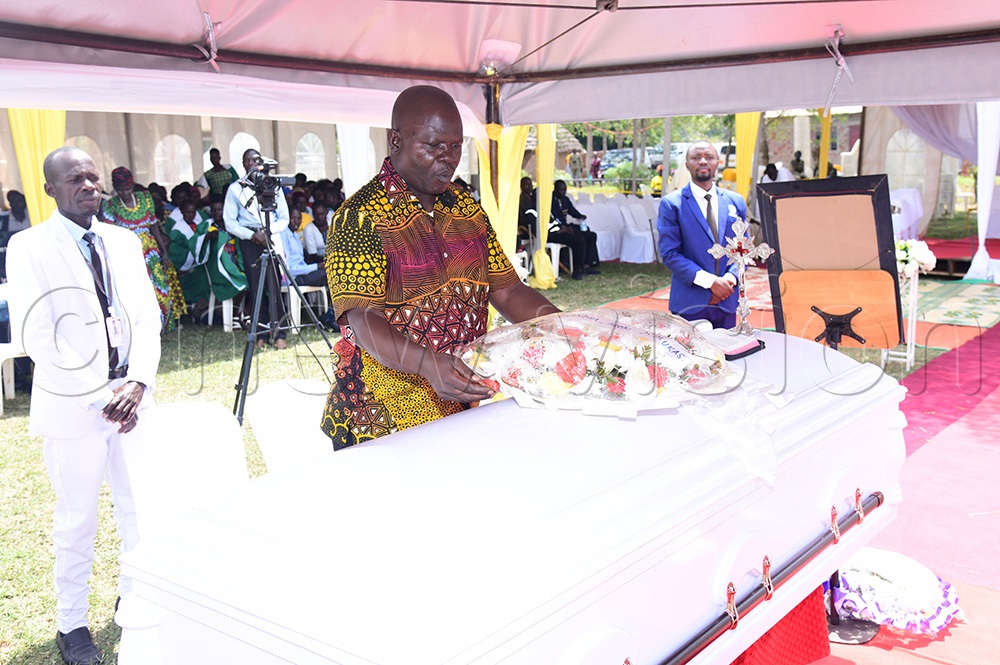 State Minister for Teso Affairs Clement Ongalo laying wreath on the casket containing the remains of Mzee Emuku. (Photo by Godfrey Ojore)