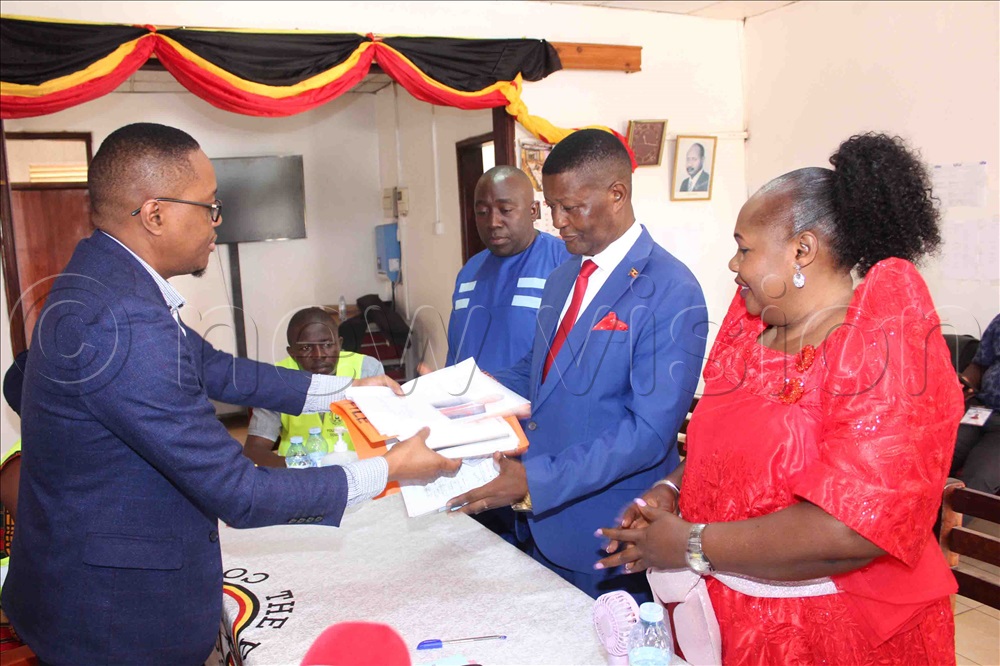 Mark Muganzi Mayanja, the Mukono Electoral Commission Returning Officer handing over nomination files to Muyanja after his nomination.