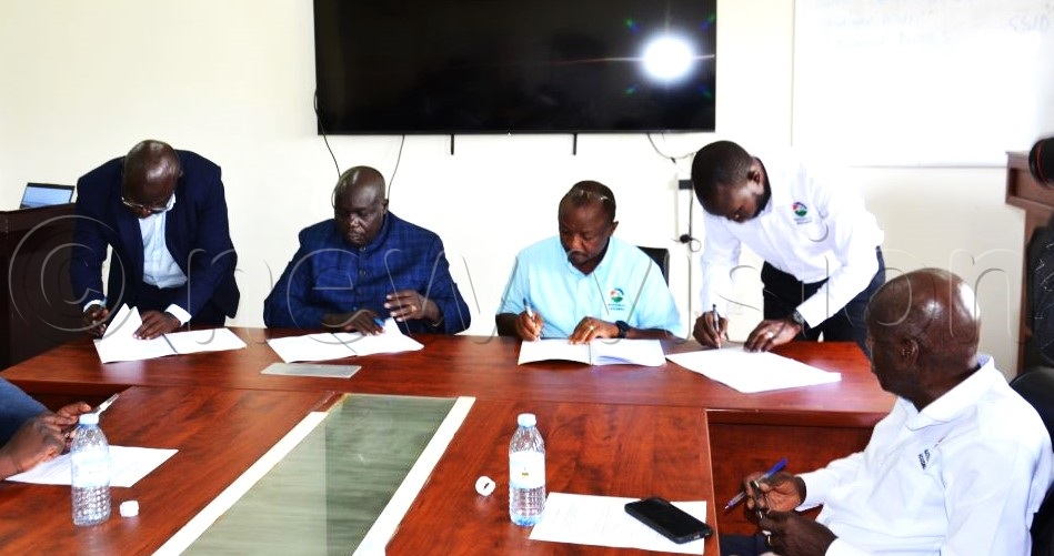 Representatives from both sides signing in the MoU documents at Muni University Council.