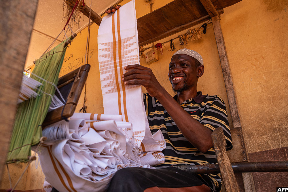  Lukman Oladejo tries to fold a finished aso-oke