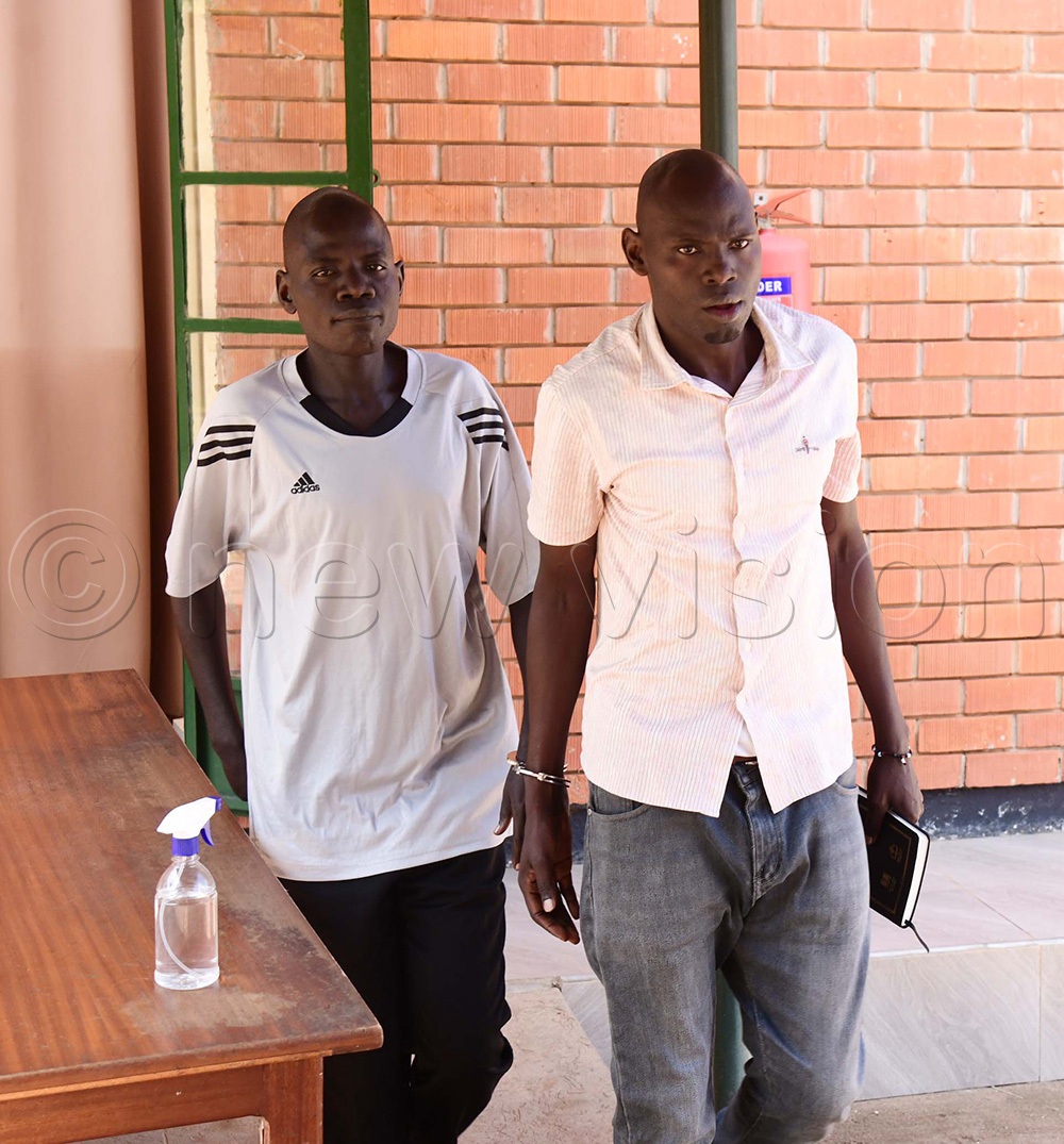 Detective Corporal John Bosco Obotol, right, with James Edoket, the school head teacher in a T-shirt, walking to the court dock. (Photo by Godfrey Ojore)