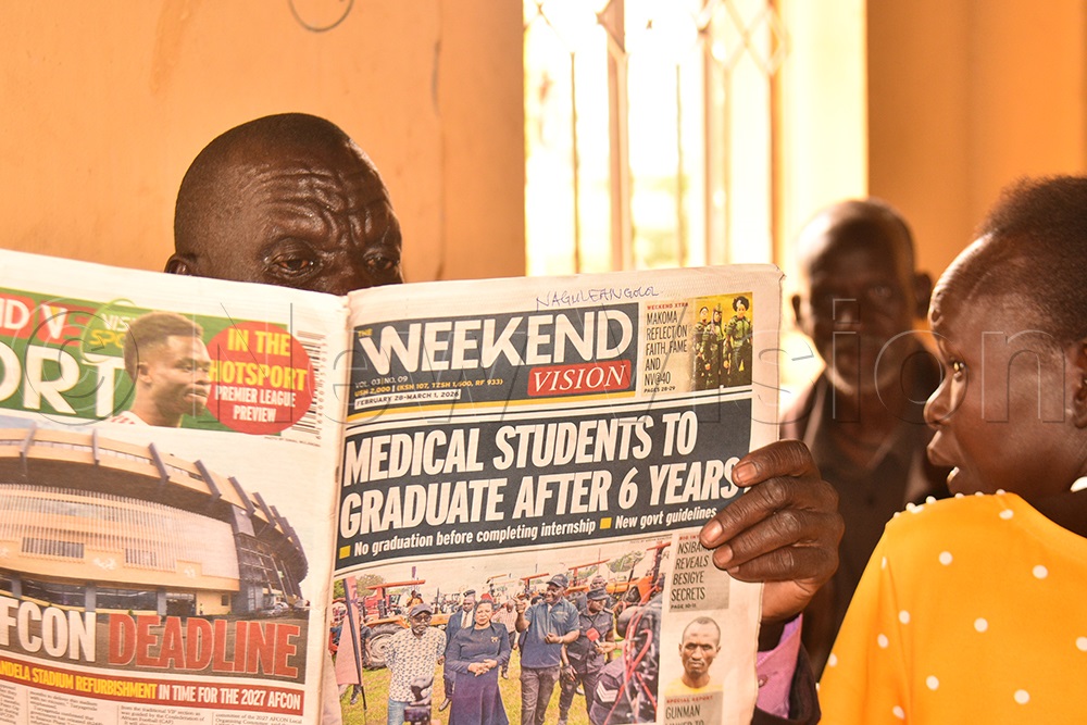 Teacher Carles Adome reading Weekend Vision to come up with a subject to teach. (Credit: Jacky Achan)