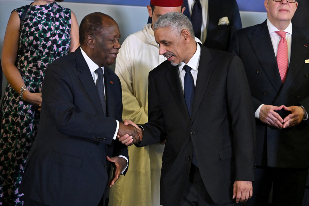 Ivorian President Alassane Ouattara of Ivory Coast (L) shakes hands with newly elected president of African Development Bank (AfDB) Sidi Ould Tah (R), while posing for photo at end of the inauguration ceremony of Tah, in Abidjan on September 1, 2025. 