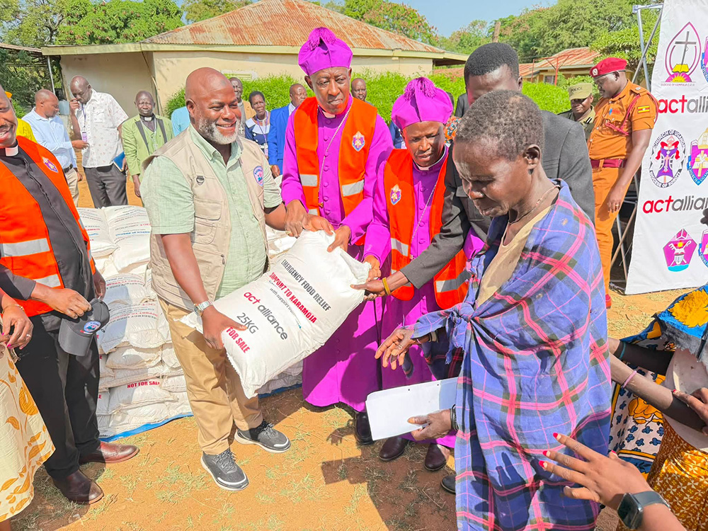 The Archbishop of the Church of Uganda (COU), Dr Stephen Samuel Kaziimba, handing over a bag of posho to one of the affected persons in the Karamoja sub-region. (Courtesy photo)
