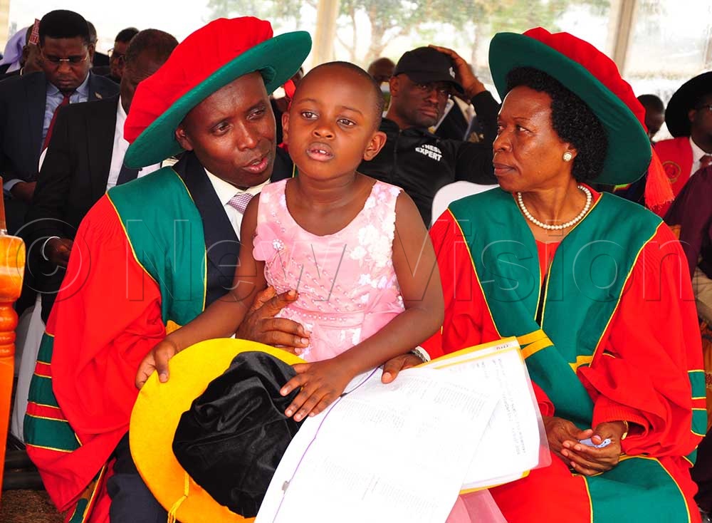 Principal Wilber Tukamuhabwa with his young daughter on graduation day. (Credit: Rwambuka Mugisha)