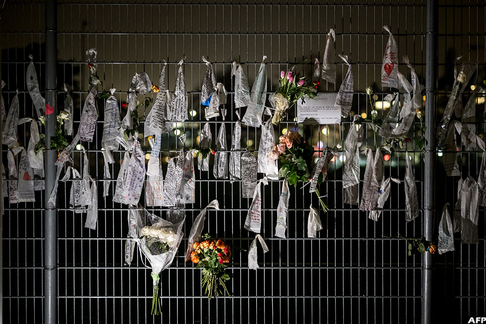 Flowers and tribute messages attached onto the fence of the football stadium of Lutry in memory of the victims of the fatal New Year's eve Crans-Montana fire
