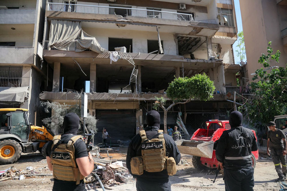 Lebanese army soldiers stand guard as people clear the rubble at the site of an Israeli airstrike that targeted a building in Beirut’s southern suburbs on June 14, 2026. (Credit: AFP)