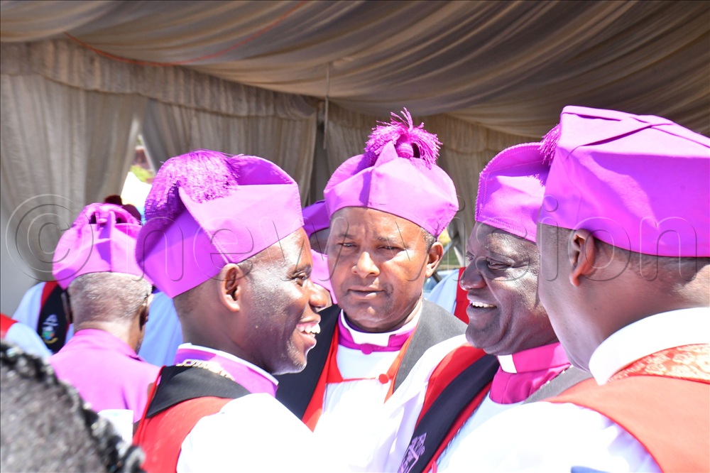 New Busoga Diocesan Bishop Rt. Rev. Canon. Associate Prof. Dr. Grace Lubaale (left) being congatulated by outgoing Bishop of Busoga Paul Samson Naimanhye (2nd right) during his enthronment at Kyabazinga Stadium in Jinja City on Sunday.