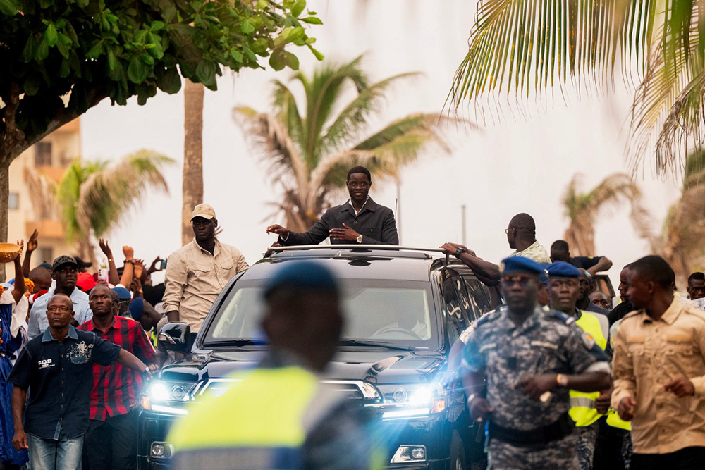 Senegal's President Bassirou Diomaye Faye (C) waves to supporters from the sunroof of his vehicle at the end of a ceremony to launch Kiiraay, his new party at the King Fahd Hotel in the Almadies district in Dakar on July 25, 2026. (Photo by SEYLLOU / AFP)