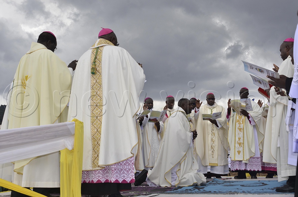 Bishops recite prayers for Bishop Bonaventure Bosco Katusiime Gubazire in the process of ordaining him as the new bishop of Kabale Diocese. (Photo by Juliet Anna Lukwago)