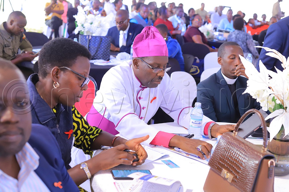Ankole Diocese Bishop Rt Rev Fred Sheldon Mwesigwa (in centre) who was the keynote speaker at the symposium, Mbarara District woman MP Margaret Rwebyambu (left) and other participants attending the last day of the 4th National HIV/AIDS Symposium held at Mbarara University of Science and Technology (MUST) grounds. (Photo by Abdulkarim Ssengendo)