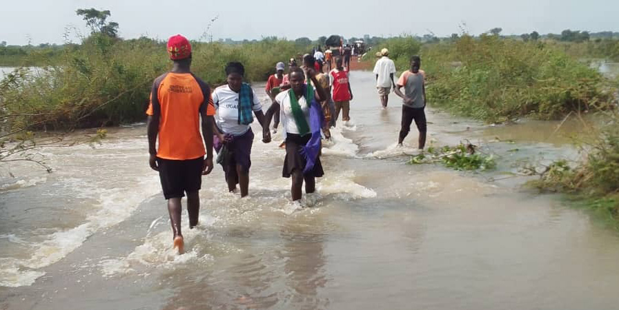  People crossing the bridge that the floods swept away last week following the ongoing rains. (Courtesy photo)