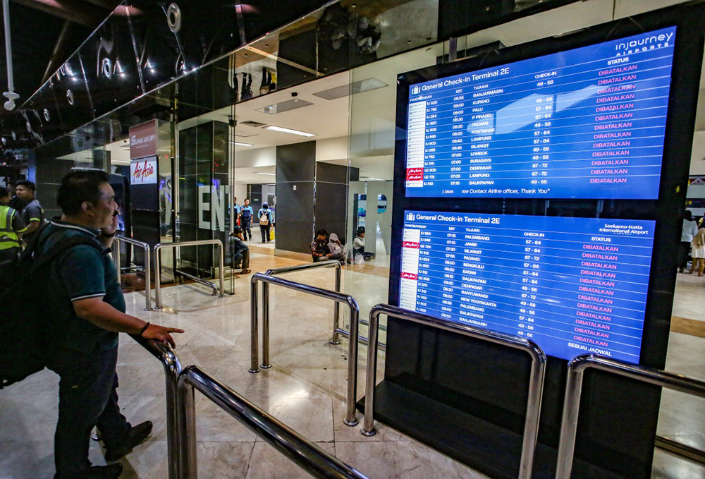 A stranded passenger looks at the departure board for the status of flights at Soekarno-Hatta Airport in Tangerang on September 6, 2026. The Airport has been temporarily closed to all flight operations due to ash spewing from the Anak Krakatoa volcano.