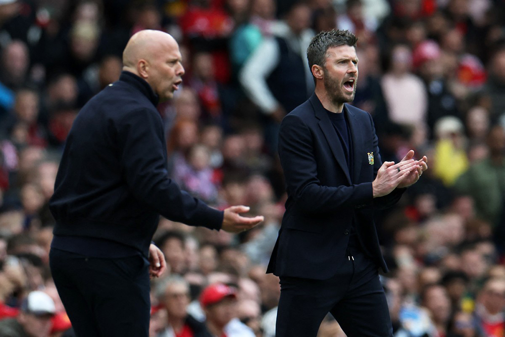 Liverpool's Dutch manager Arne Slot (L) and Manchester United's English Interim head coach Michael Carrick (R) react during the English Premier League football match between Manchester United and Liverpool at Old Trafford in Manchester, north west England, on May 3, 2026. 