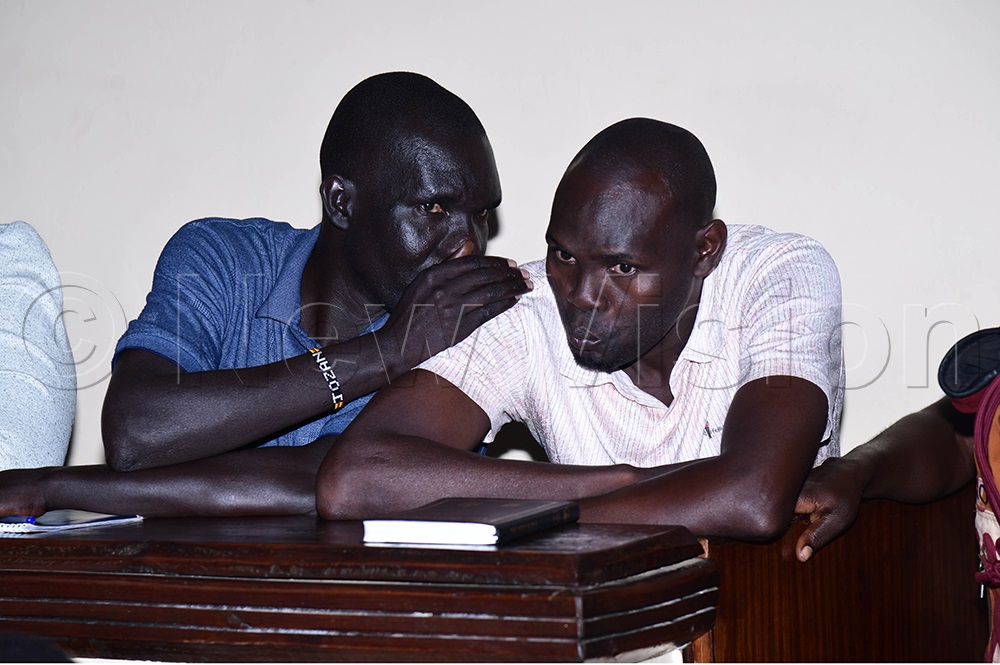 Joseph Okedi and his younger brother, John Bosco Obotol, confer in the dock after being convicted of murder by the High Court in Soroti. (Photo by Godfrey Ojore)