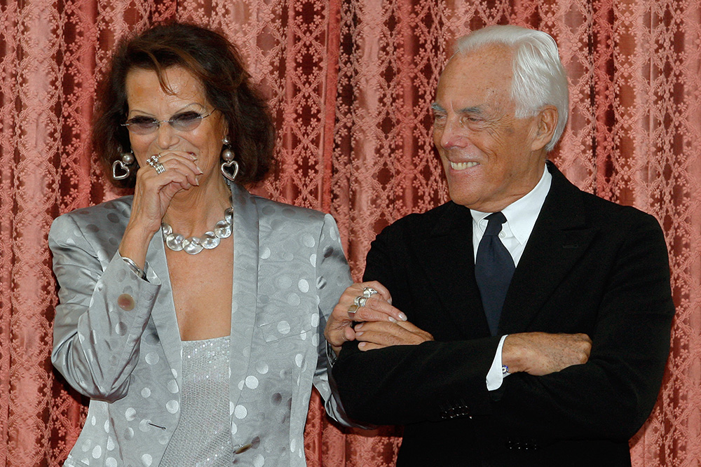 Italian actress Claudia Cardinale and fashion designer Giorgio Armani smile as they attend a ceremony at the Elysee presidential palace in Paris, where they received the French Legion d'Honneur medal, on July 3, 2008. (Photo by BENOIT TESSIER / POOL / AFP)
