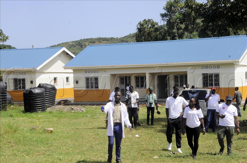 Gastafas Nyenje, a laboratory technician (left) takes members of the Rotary Club of Nakasero to some of the staff houses at the new facilities at Lwamata Health Centre III in Kiboga district.