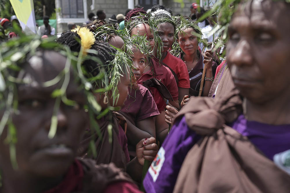 Young Ogiek women spotting wreaths fashioned from reeds line up as they prepare to give a traditional performance during a cultural showcase at the 6th Annual Ogiek Cultural festival at Nkareta ward, Narok County, on August 15, 2025. (Credit: AFP)