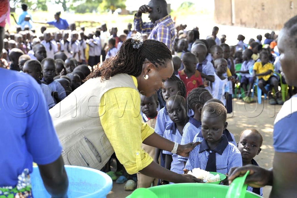 Dinah Morgan, the country Director Stromme Foundation serving food to children in Sacred Heart ECD in Obongi district. (Credit: Robert Ariaka)