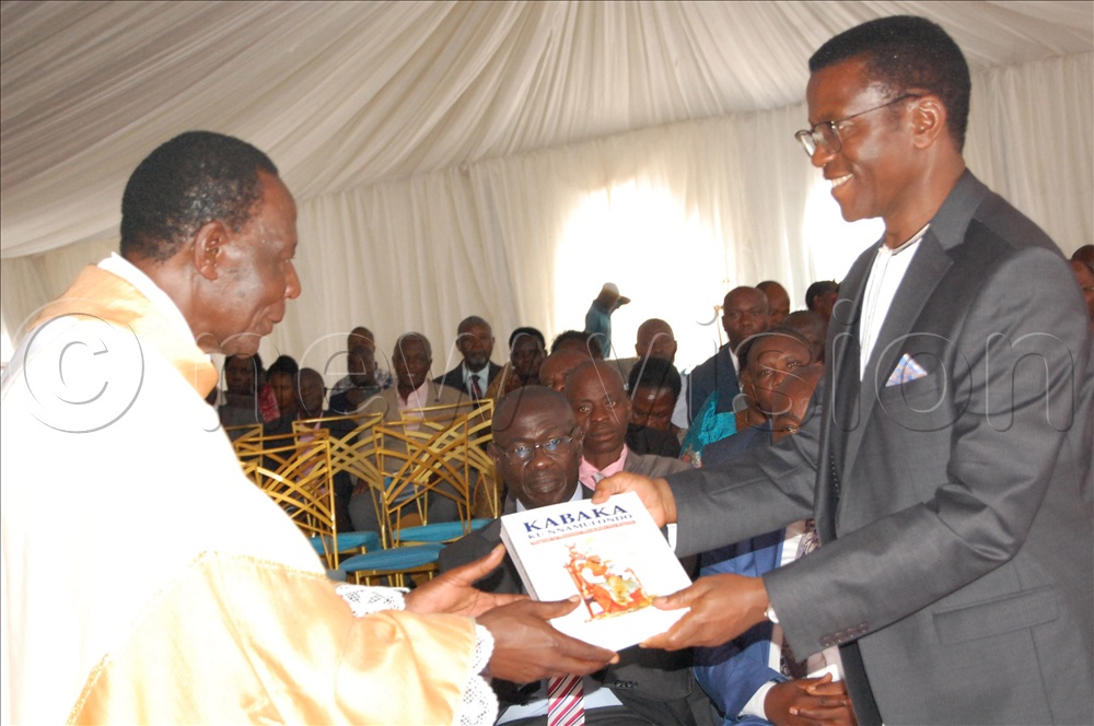 Katikkiro Charles Peter Mayiga (tight) gifting Fr. Kyemwa